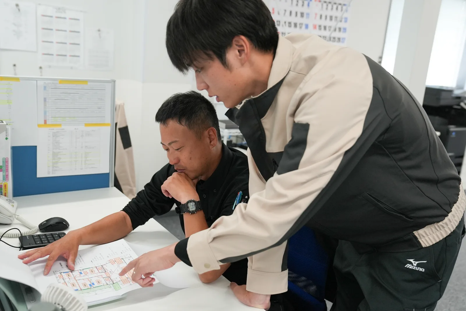 図面を見ながら相談する社員