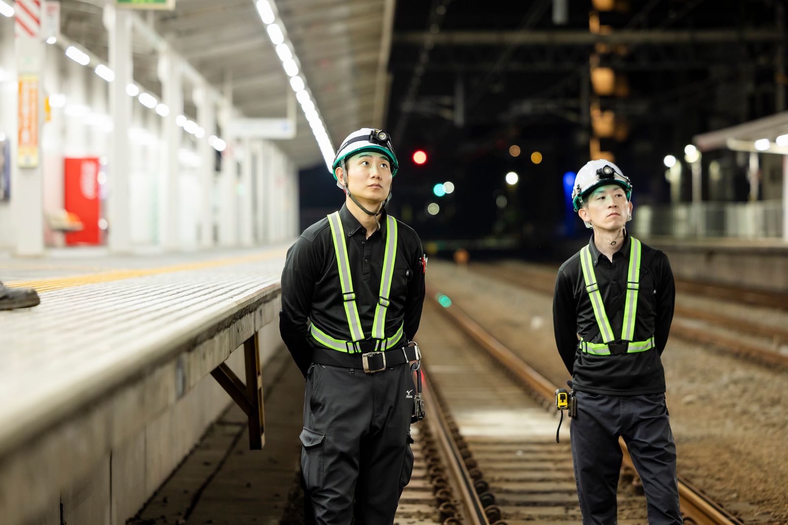 駅の線路上で作業箇所を確認する社員