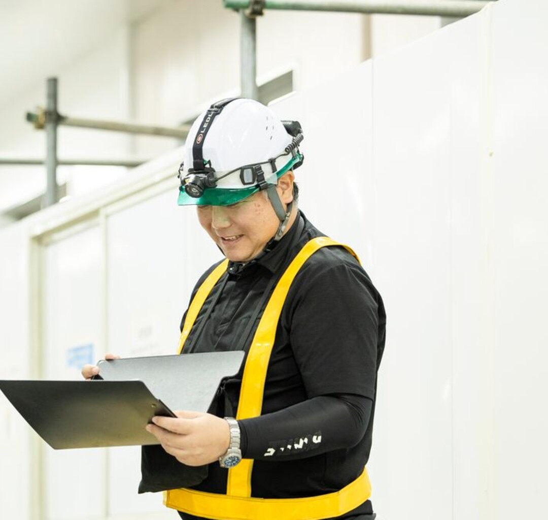 現場でファイルを確認するベテラン施工管理社員