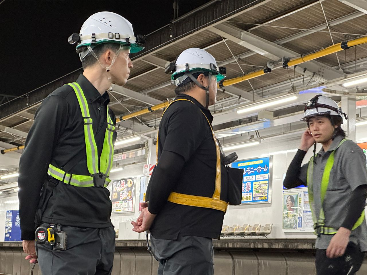 駅ホームで打ち合わせを行う作業員