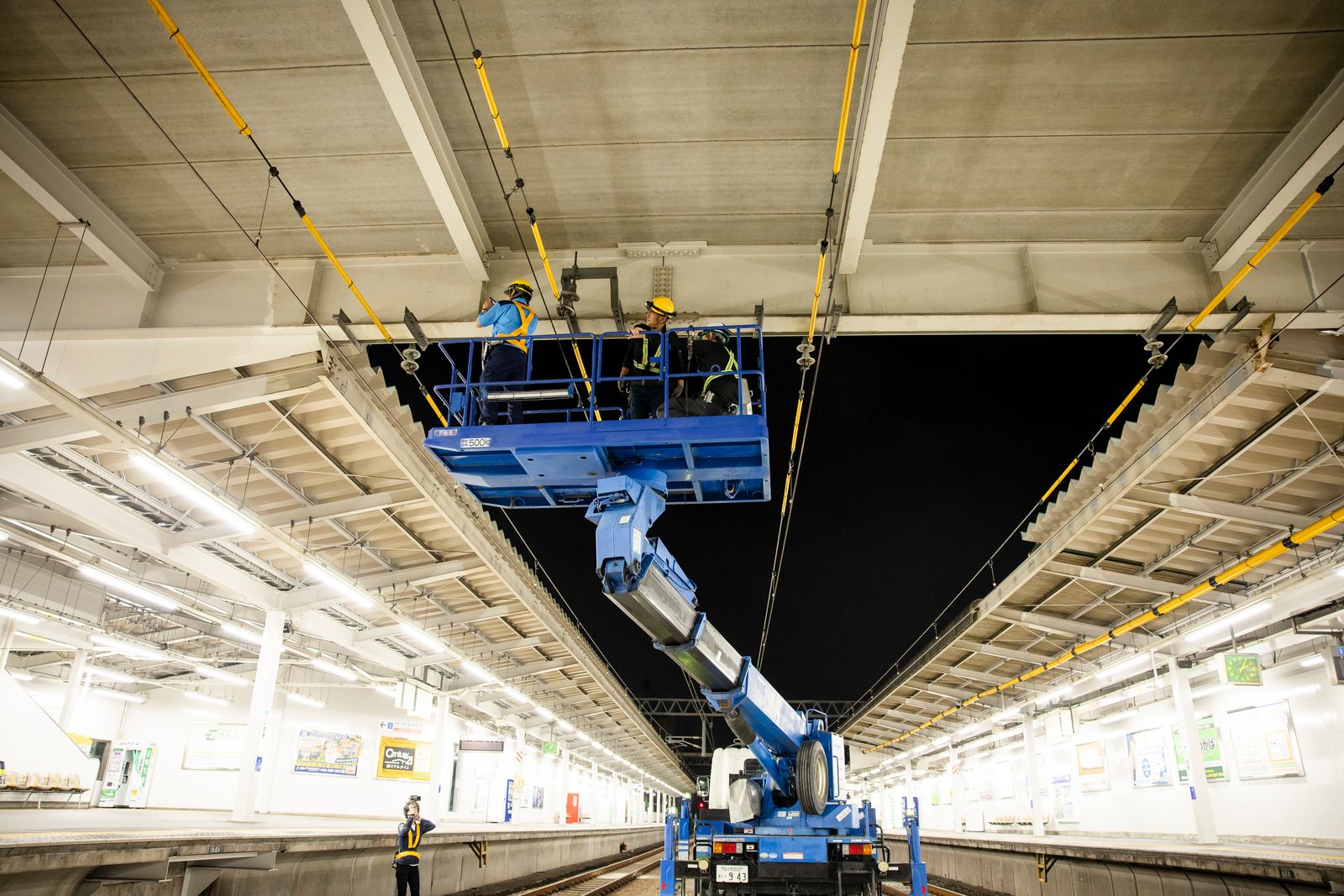 高所作業車で駅ホーム上屋を施工する作業員