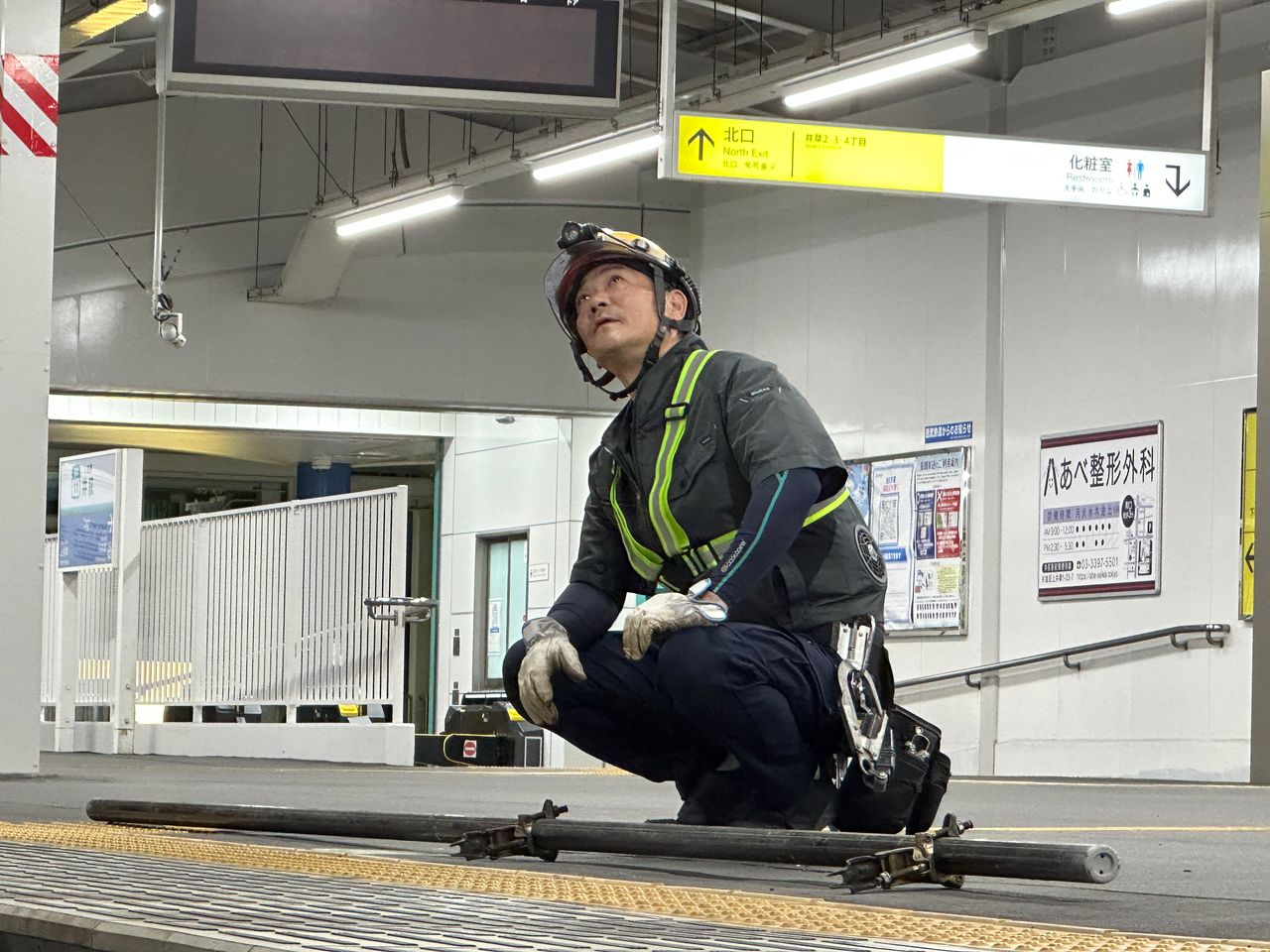 駅ホームで設備を確認する施工管理スタッフ