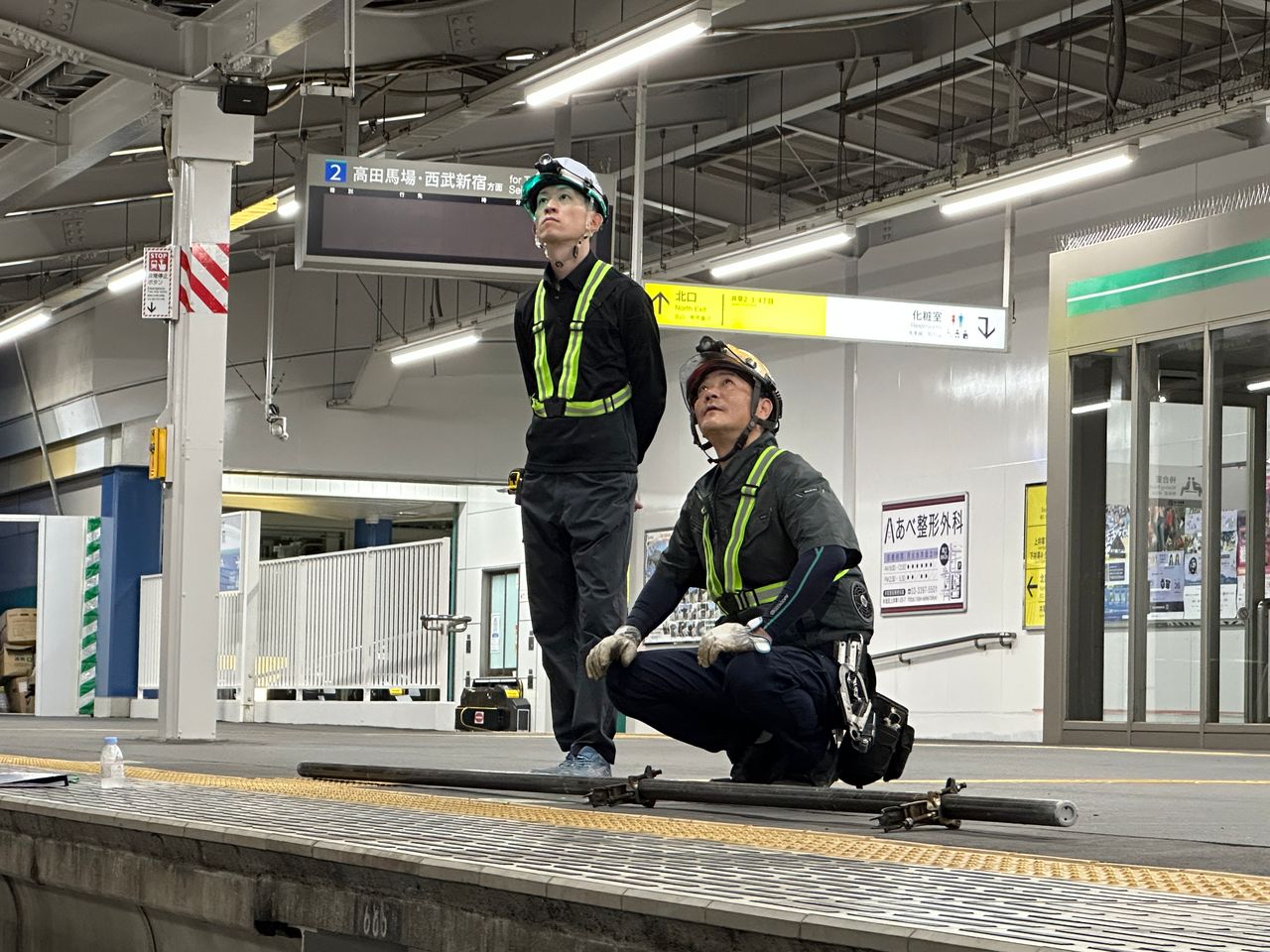 駅ホームで設備を確認する施工管理スタッフ