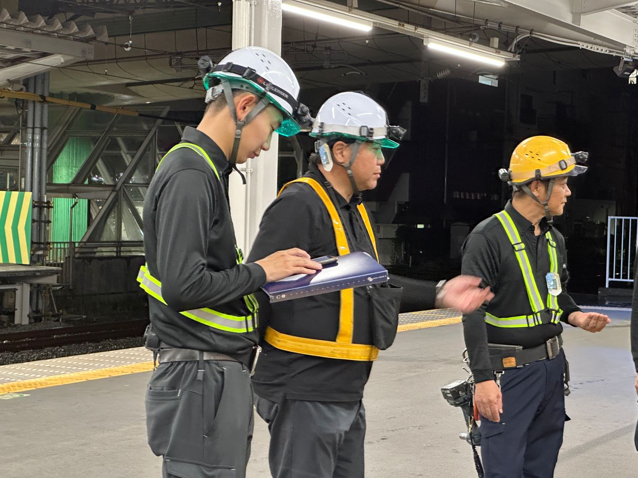 駅構内で図面を確認する施工管理スタッフ