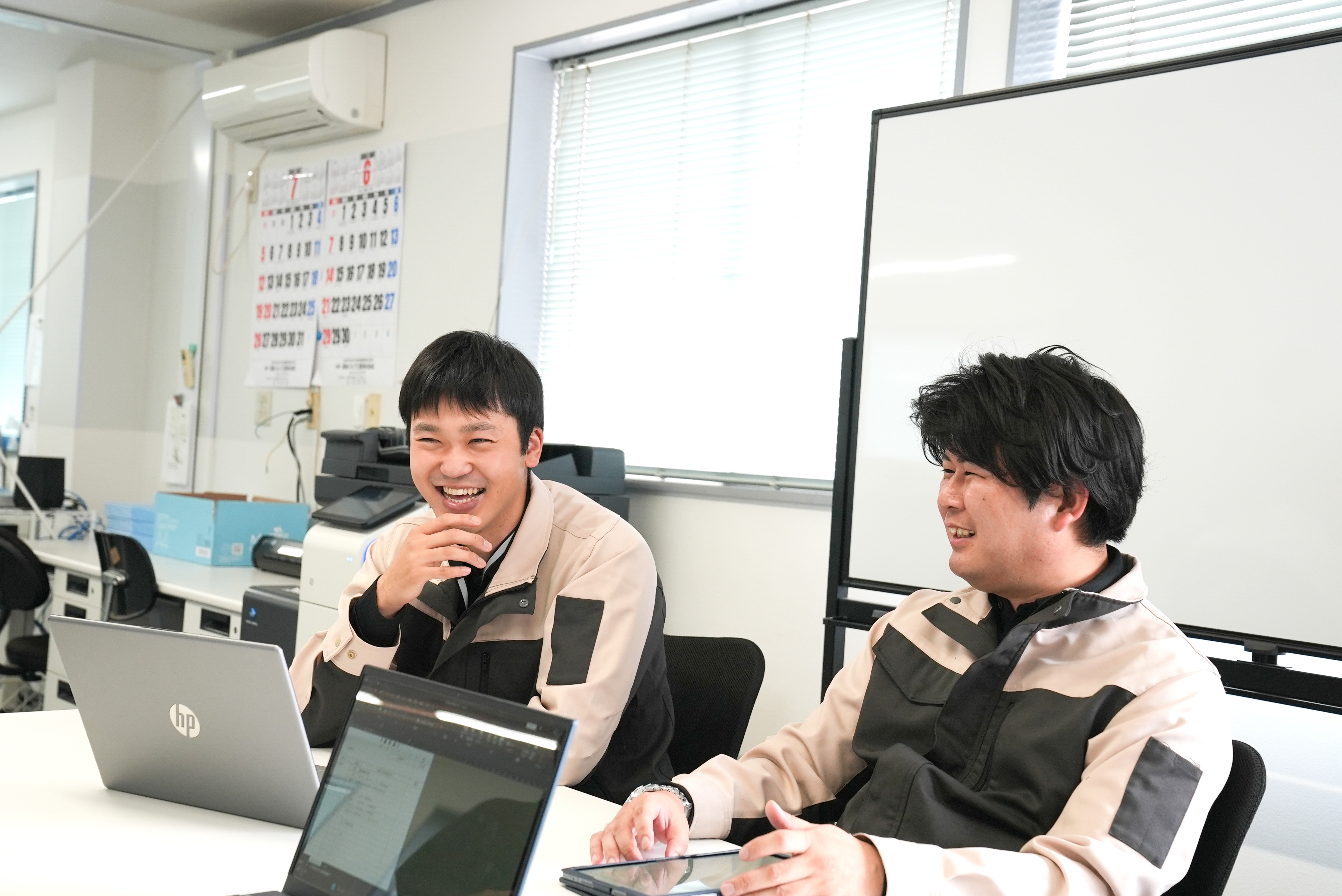 オフィスで笑顔で話す若手社員
